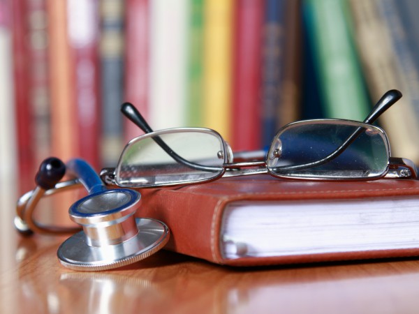 Stethoscope on book with leather cover.