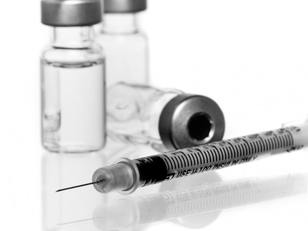 three vials with hypodermic needle